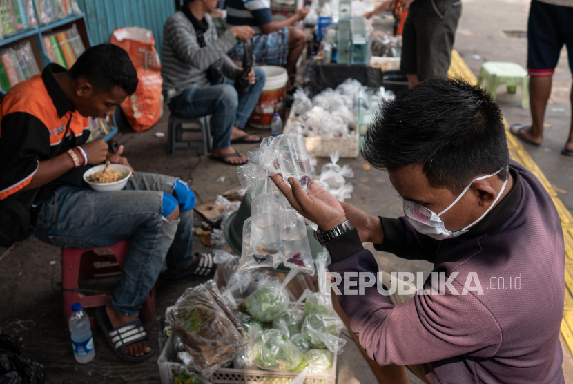 Calon pembeli memilah ikan hias di pasar ikan hias Jatinegara, Jakarta, Ahad (19/4). Tren ikan cupang membuat Pasar Ikan Jatinegara ramai, terutama pada malam hari.