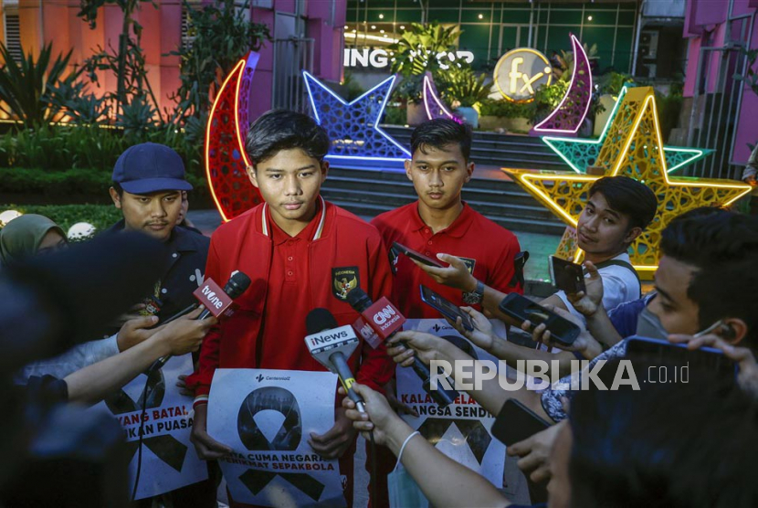  Anggota Timnas U-20 Indonesia Arkhan Kaka (kiri tengah) dan Aditya Nugraha (kanan tengah) berbincang dengan wartawan sambil memegang plakat bergambar pita hitam sebagai tanda berkabung menyusul pengumuman FIFA yang mencabut status tuan rumah Indonesia untuk Piala Dunia U-20 2023 selama reli di Jakarta, Jumat (31/3/2023). FIFA resmi mencabut status Indonesia sebagai tuan rumah Piala Dunia U-20 2023 mendatang, dengan potensi sanksi terhadap Persatuan Sepak Bola Seluruh Indonesia (PSSI) akan diputuskan di kemudian hari.