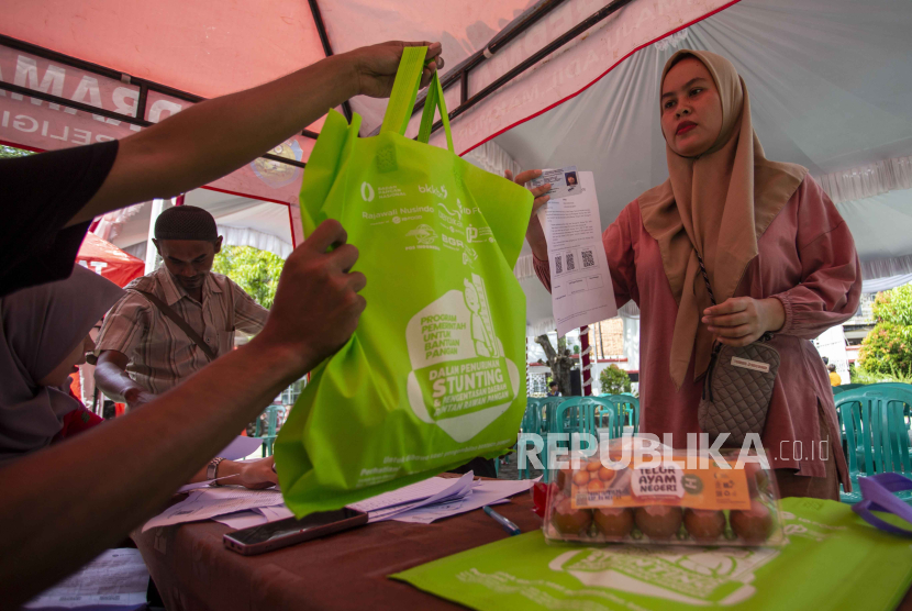 Warga menerima paket telur dan daging ayam saat penyaluran bantuan pangan penanganan stunting di Indramayu, Jawa Barat