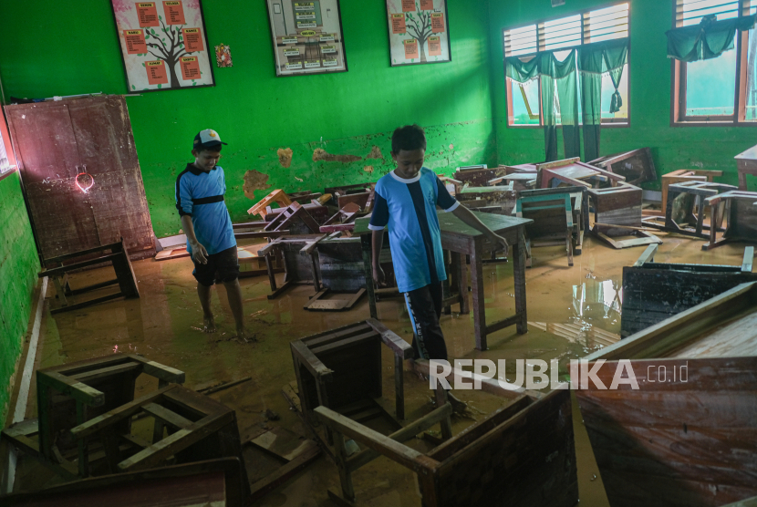 Dua orang pelajar di dalam ruang belajar pascabanjir bandang di SMP 2 Kendari, Kendari, Sulawesi Tenggara. Pemkot Kendari menyiapkan 3 dapur umum untuk pengungsi sahur dan buka puasa.