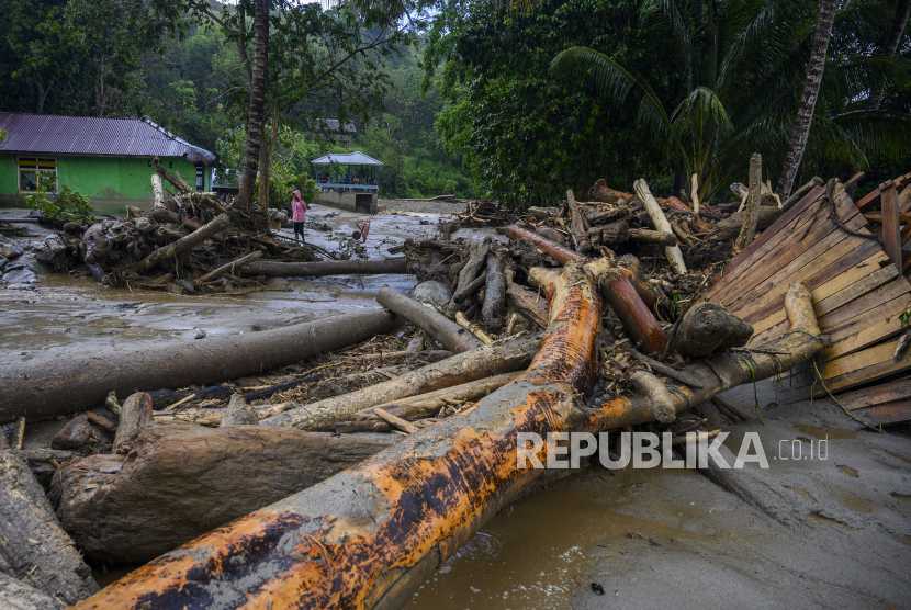 Warga berada di dekat puing rumah yang hancur akibat diterjang banjir bandang di Desa Oloboju, Kabupaten Sigi, Sulawesi Tengah, Sabtu (11/7/2020). Banjir bandang yang terjadi pada Jumat (10/7/2020) malam karena hujan deras dan membawa material lumpur dan kayu-kayu itu menyapu sejumlah  rumah warga dan menghanyutkan ternak serta merusak ratusan hektar lahan pertanian milik warga (Foto: banjir Sigi)