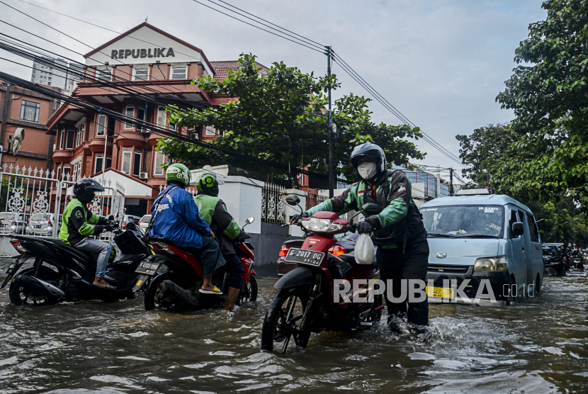 Warga mendorong motor yang mogok saat terjadi banjir di Jalan Pejaten Raya, Jakarta, Sabtu (20/2). Intensitas hujan yang tinggi menyebabkan banjir di sejumlah wilayah Jakarta serta menyebabkan sebagian ruas jalan tidak dapat dilewati kendaraan. Republika/Putra M. Akbar