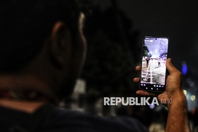 Warga melakukan live tiktok saat aksi 28 Agustus 2025 di Kawasan Pejompongan, Jakarta, Kamis (28/8/2025). Aksi yang digelar untuk mengkritisi kinerja anggota dewan serta pemberian tunjangan perumahan bagi anggota DPR tersebut berakhir ricuh.