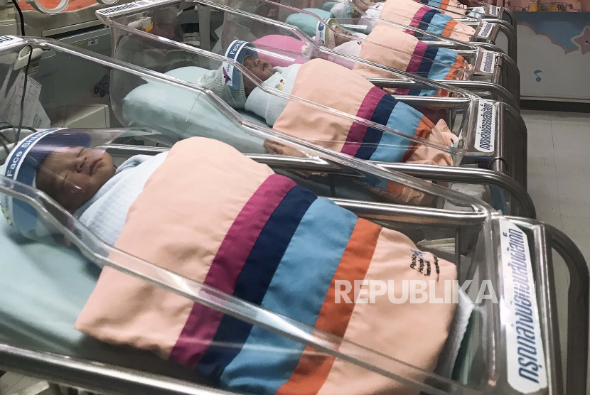 Pada Jumat 3 April 2020 ini, foto yang dikeluarkan oleh Rumah Sakit Paolo Samutprakarn Seorang perawat merapikan pelindung wajah kecil untuk bayi yang baru lahir di kamar bayi Rumah Sakit Provinsi Samutprakarn, Thailand. Thailand berjuang keras untuk mendorong rakyatnya memiliki lebih banyak bayi.