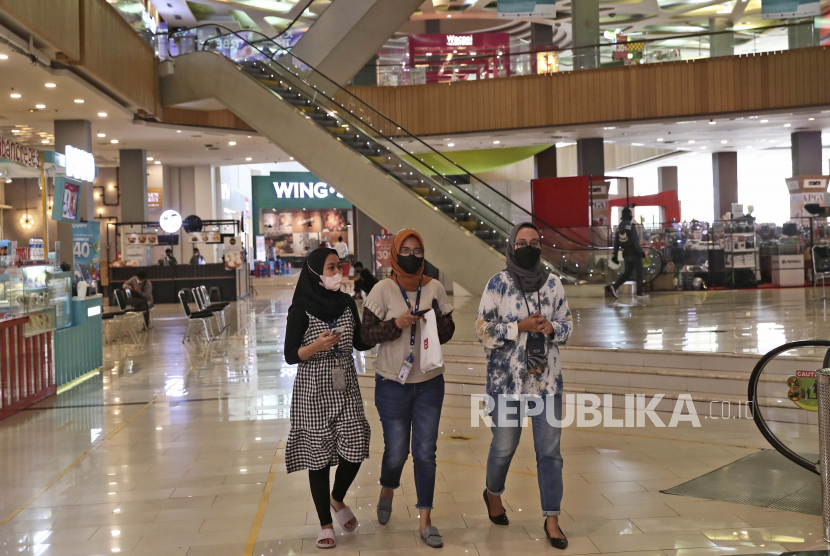 Wanita mengenakan masker wajah sebagai tindakan pencegahan terhadap wabah virus corona berjalan di dalam pusat perbelanjaan di Tangerang, Indonesia, Kamis, 18 November 2021.