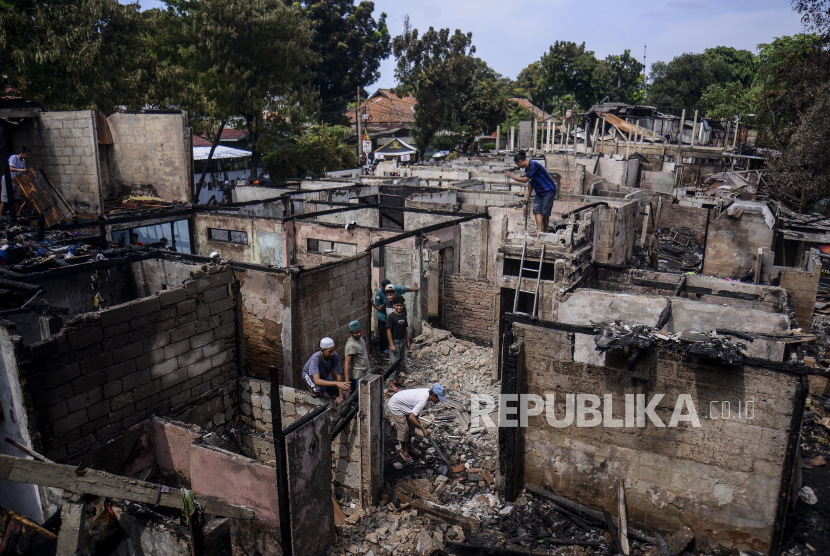 Warga membongkar bangunan pasca kebakaran di kawasan Manggarai, Jakarta, Ahad (18/12/2022). Kebakaran yang terjadi pada Sabtu (17/12/2022) tersebut menghanguskan 52 rumah semi permanen yang diduga akibat sambaran petir. Republika/Putra M. Akbar