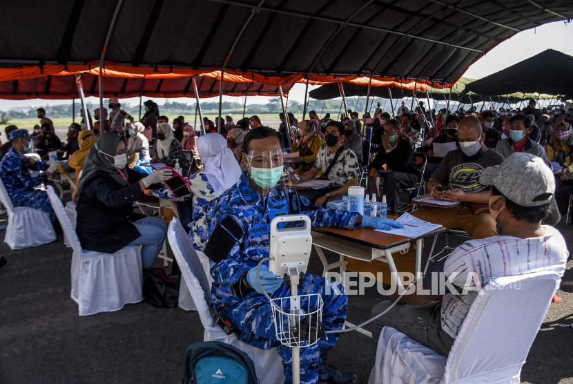 Sejumlah warga menjalani pemeriksaan kesehatan sebelum disuntik vaksin Covid-19 di Lanud Husein Sastranegara, Kota Bandung, Senin (26/7). Serbuan vaksinasi dan pembagian sembako yang digelar TNI AU Badan Koordinasi Daerah (Bakorda) Bandung dalam rangka memperingati Hari Bakti TNI AU ke-74 tersebut menyediakan 4.000 dosis vaksin serta 4.000 paket sembako untuk membantu masyarakat yang terdampak pandemi Covid-19. Foto: Republika/Abdan Syakura
