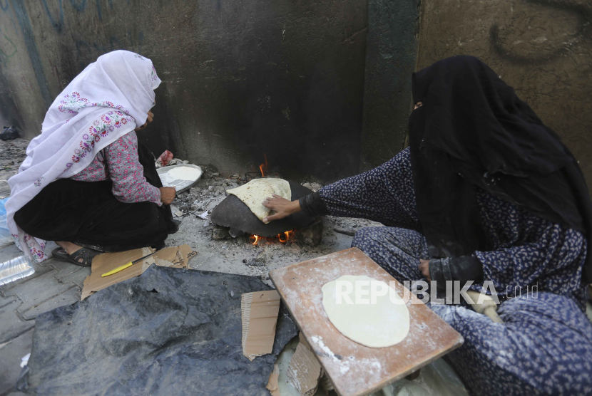 Seorang wanita Palestina membuat roti di Rafah, Jalur Gaza, Kamis, 16 November 2023.