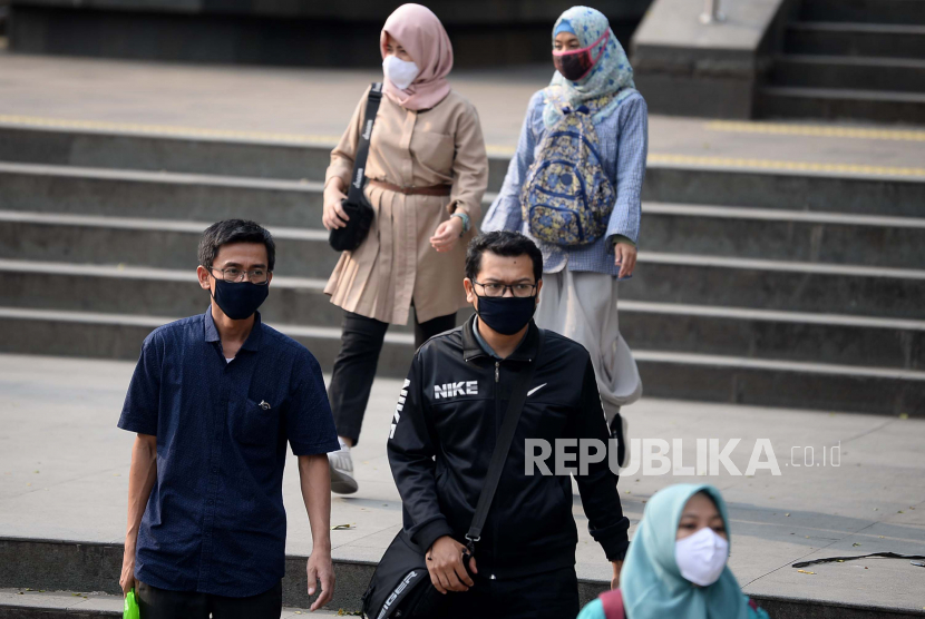 Sejumlah pekerja berjalan di Trotoar di Kawasan Duku Atas, Jakarta, Selasa (12/5). Pemerintah mengklarifikasi rencana pelonggaran pembatasan sosial dengan mengizinkan warga dengan usia di bawah 45 tahun untuk kembali bekerja dan beraktivitas normal