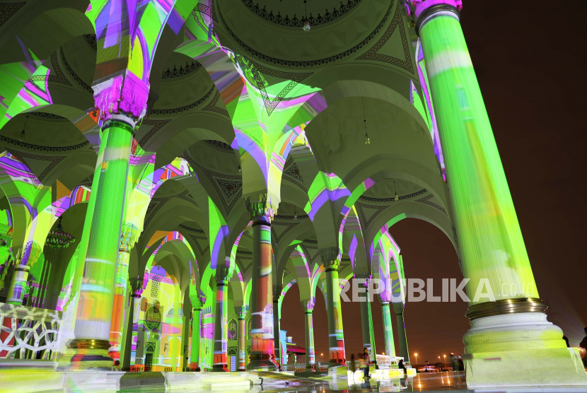 Orang-orang melihat Masjid Sharjah yang diterangi selama Festival Cahaya Sharjah di emirat Teluk Sharjah, Uni Emirat Arab, 13 Februari 2022. Tradisi Ramadhan di UEA, 40 Hari Menuju Bulan Suci