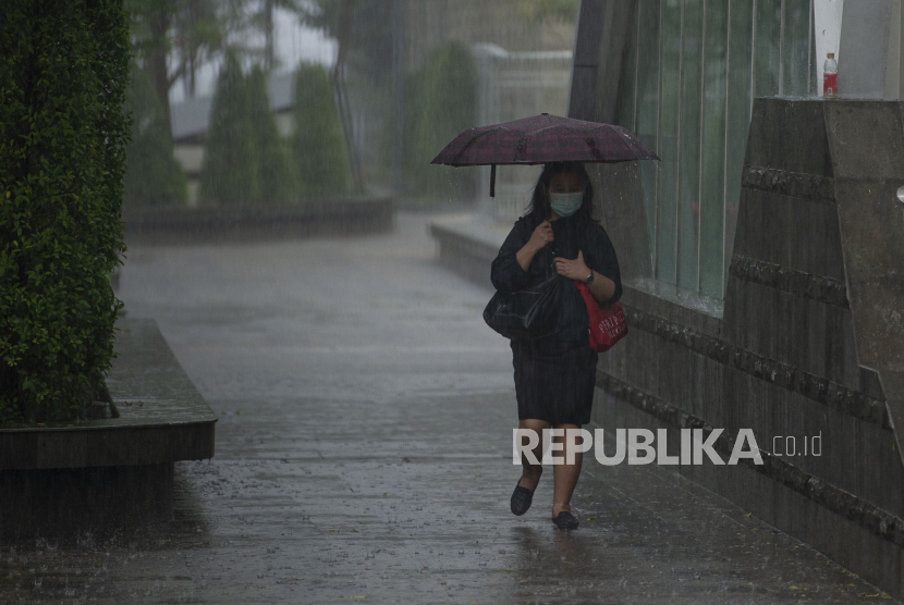 Warga menggunakan payung saat hujan mengguyur Stasiun MRT.  PT MRT Jakarta tengah menyiapkan langkah-langkah pencegahan banjir. 