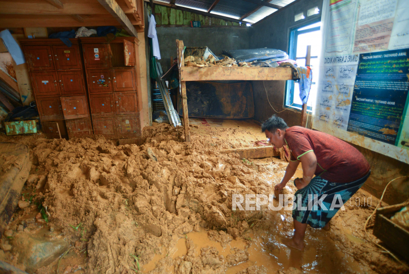 Warga berusaha membersihkan ruangan dari material longsor yang menimpa sebuah panti asuhan di Kampung, Padang, Sumatera Barat, Jumat (14/7/2023). 
