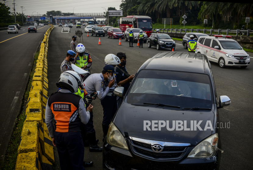 Sejumlah petugas gabungan memeriksa mobil yang keluar dari Gerbang Tol Bogor saat melakukan penyekatan di Bogor, Jawa Barat, Jumat (7/5). Satgas Covid-19 melarang adanya mudik lokal di kawasan aglomerasi selama 6 Mei hingga 17 Mei 2021, untuk mencegah penyebaran Covid-19. Republika/Putra M. Akbar