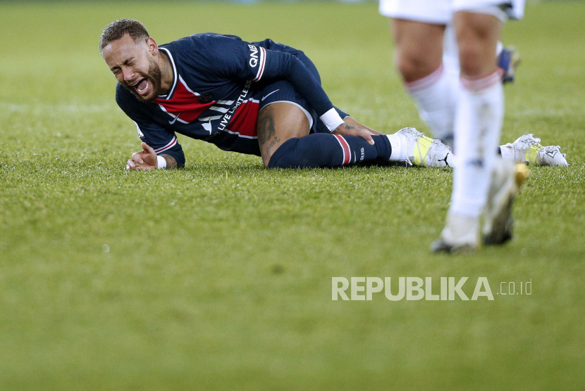 Neymar Jr dari Paris Saint Germain (PSG) bereaksi kesakitan saat dibekap cedera dalam sebuah pertandingan.