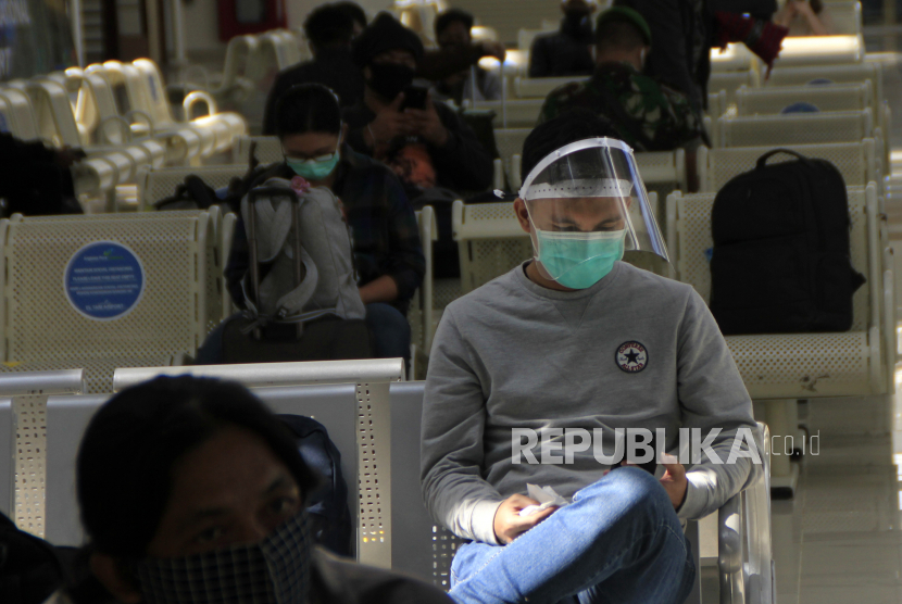 Seorang penumpang pesawat menggunakan pelindung wajah duduk di ruang tunggu keberangkatan bandara El Tari Kupang, NTT, Senin (8/6/2020). Pemerintah membuat aturan menaikkan kapasitas penumpang pesawat hingga 70 persen.