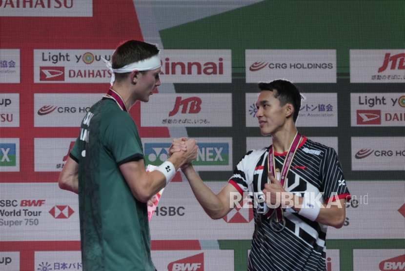 Viktor Axelsen dari Denmark (kiri) dengan medali emas, dan Jonatan Christie dari Indonesia dengan medali perak, berjabat tangan saat penyerahan medali tunggal putra turnamen bulu tangkis Japan Open di Tokyo, Ahad, (30/7/2023).