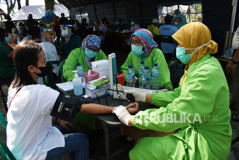 Petugas  memeriksa kesehatan warga sebelum mendapatkan suntikan vaksin COVID-19 saat Vaksinasi Massal COVID-19 di Korem 081/Dhirotsaha Jaya Madiun di Ngrowo Bening Edupark Kota Madiun, Jawa Timur, Selasa (29/6/2021). Kegiatan vaksinasi massal yang menyiapkan 2.416 dosis vaksin tersebut dalam upaya percepatan vaksinasi pada warga guna pencegahan COVID-19. 