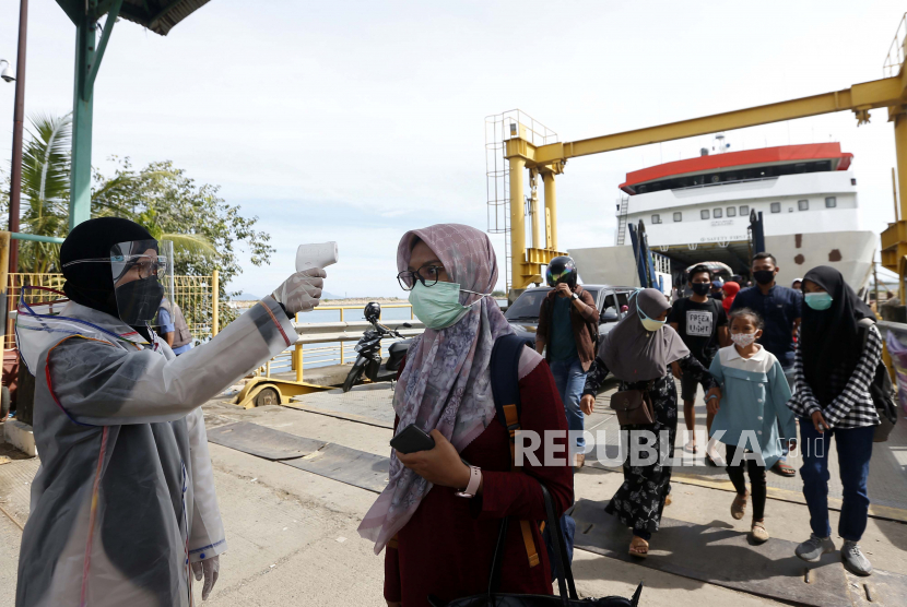 Petugas kesehatan pelabuhan memeriksa suhu tubuh penumpang kapal (ilustrasi). PT ASDP Indonesia Ferry (Persero) mengimbau penumpang dapat lebih awal tiba di pelabuhan pada masa angkutan Natal dan Tahun Baru 2020/2021.