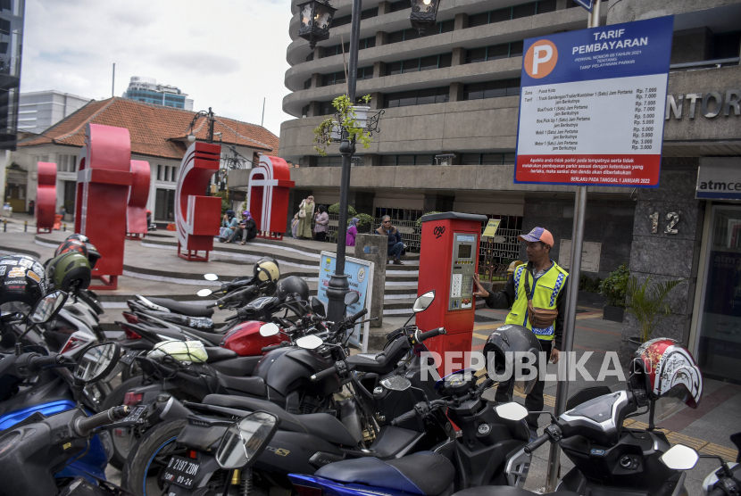 Juru parkir membantu pengendara yang akan parkir di Jalan Braga, Kota Bandung, Kamis (5/1/2023). 