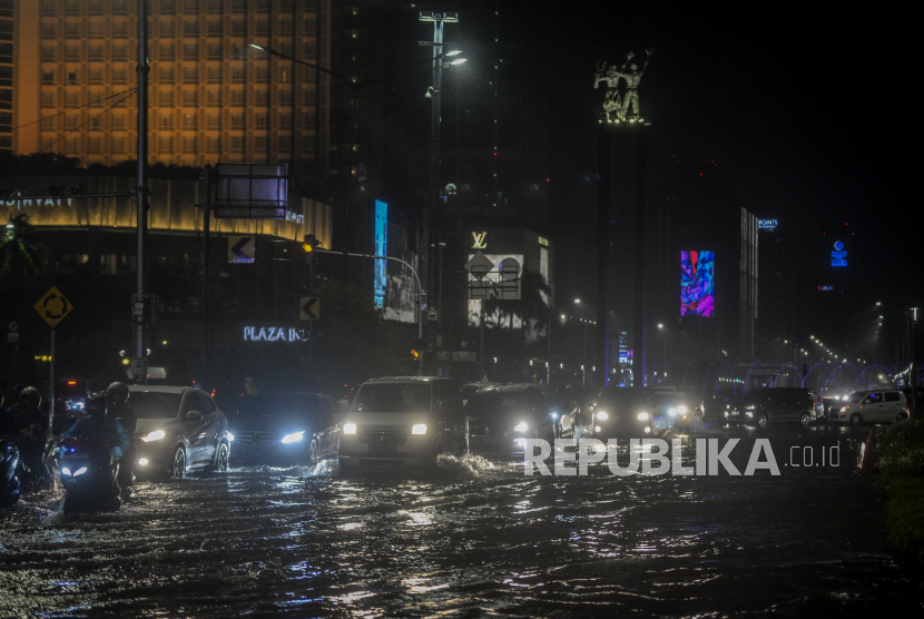 Sejumlah kendaraan melewati genangan air di kawasan Bundaran HI, Jakarta, Senin (21/9). Hujan deras yang mengguyur wilayah Ibu Kota menyebabkan genangan air di sejumlah jalan protokol sehingga menghambat laju kendaraan yang melintas. Republika/Putra M. AKbar