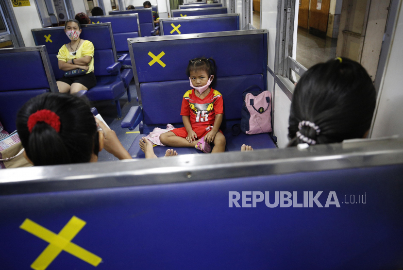 Seorang gadis duduk bersama orang tuanya di gerbong penumpang kereta di Stasiun Kereta Api Hua Lamphong di Bangkok, Thailand, Senin (18/5). Thailand memperpanjang status darurat corona hingga 30 Juni.