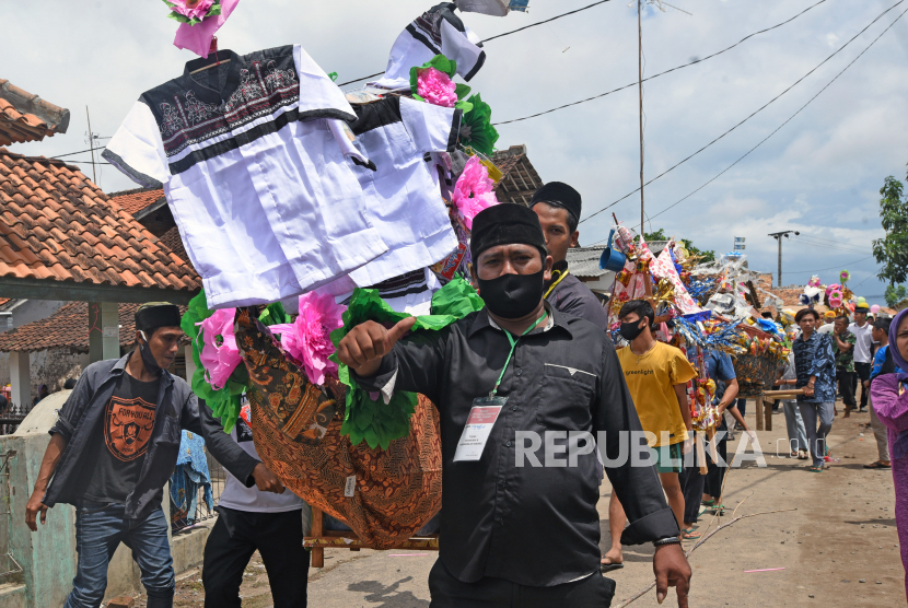 Warga menggotong aneka barang sedekah saat Perayaan Maulid Nabi Muhammad SAW di Kampung Tegalparang, Soyog, Serang, Banten, Ahad (1/11/2020). 