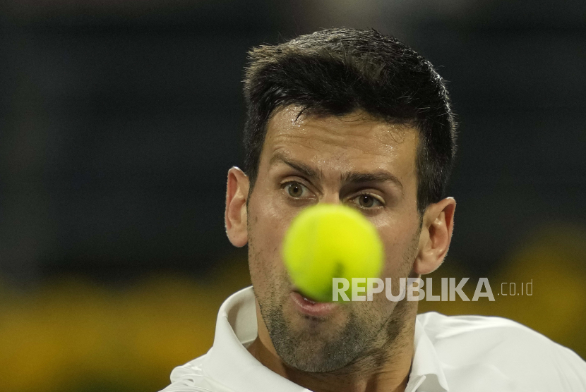 Petenis Serbia Novak Djokovic mengembalikan bola kepada pebalap Italia Lorenzo Musetti dalam pertandingan Kejuaraan Tenis Bebas Bea Dubai di Dubai, Uni Emirat Arab, Senin, 21 Februari 2022.