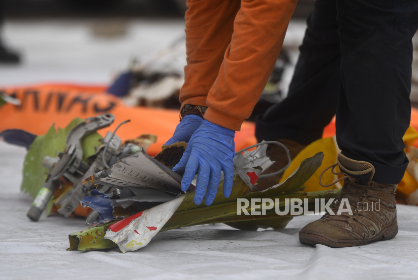 Petugas menata serpihan pesawat Sriwijaya Air SJ 182 rute Jakarta - Pontianak yang jatuh di perairan Pulau Seribu, di Dermaga JICT, Jakarta, Senin (11/1/2021). Serpihan-serpihan tersebut nantinya akan diperiksa oleh Komisi Nasional Keselamatan Transportasi (KNKT) untuk mencari penyebab jatuhnya pesawat. 