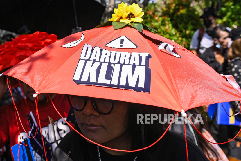 Seorang aktivis memakai topi payung aspirasi saat mengikuti aksi Darurat Iklim di Jakarta, Jumat (27/9/2024). Aksi tersebut menuntut pemerintah agar segera mengambil kebijakan untuk memitigasi kerusakan lingkungan dan perlindungan terhadap lingkungan hidup di wilayah Indonesia. 