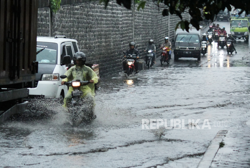 Kendaraan melewati genangan cileuncang atau genangan air hujan yang merendam ruas jalan di bawah Flyover Cimindi.