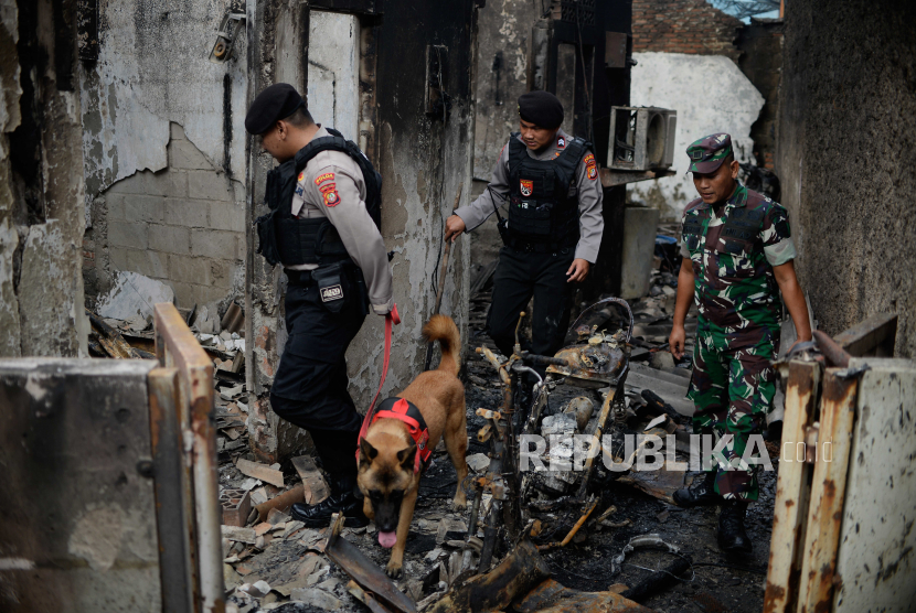 Polisi menggunakan anjing K-9 untuk mencari korban kebakaran depo Pertamina Plumpang di kawasan Rawa Badak, Jakarta, Sabtu (4/3/2023). Polda Metro Jaya menurunkan anjing K-9 untuk membantu pencarian korban yang masih tertimbun reruntuhan bangunan pasca kebakaran depo Pertamina Plumpang.