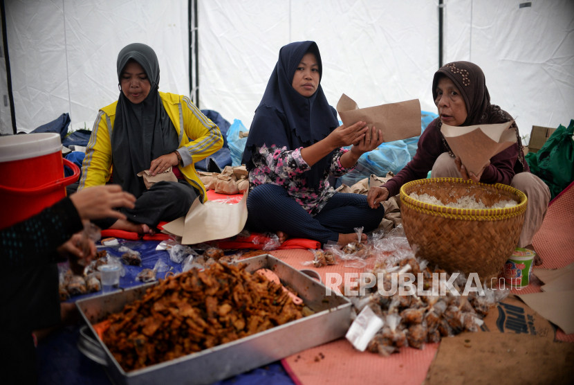 Relawan menyiapkan hidangan makan malam untuk pemgungsi korban gempa Cianjur di posko relawan Kecamatan Cugenang, Kabupaten Cianjur, Jawa Barat, Jumat (25/11/2022). Dalam satu hari mereka mendistribusikan makanan sebanyak 3000 porsi yang dibagikan ke beberapa titik posko pengungsi di Kecamatan Cugenang. Republika/Thoudy Badai