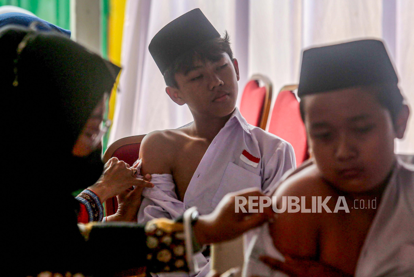 Petugas kesehatan menyuntikan vaksin Japanese Encephalitis (JE) ke pelajar saat pencanangan imunisasi JE di Pondok Pesantren Pandanaran, Sleman, D.I Yogyakarta, Senin (2/9/2024). Pemda Sleman memberikan vaksin gratis untuk anak usia 9 bulan hingga 15 tahun selama bulan September - Oktober 2024 guna mengantisipasi penyebaran penyakit Japanese Encephalitis (JE) yang ditularkan oleh nyamuk Culex. 