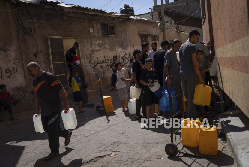 Warga Palestina mengambil air dari keran air, di tengah kekurangan air minum, di Khan Younis, Jalur Gaza, Senin, (16/10/2023)WIB. 