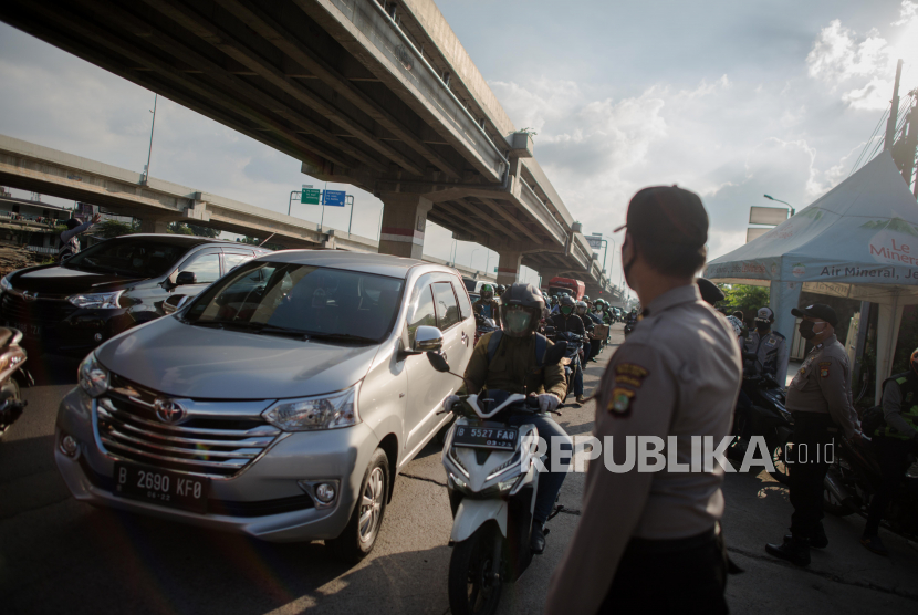 Petugas gabungan mengatur lalu lintas di cek point PSBB dan mudik di kawasan Jalan Raya Kalimalang perbatasan Jakarta-Bekasi, Jawa Barat, Selasa (19/5). Lalu lintas jalur Kalimalang mengalami kenaikan volume kendaraan roda dua mencapai 1500 per hari pada H-5 hari raya idul fitri