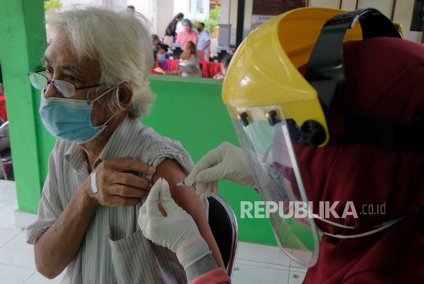 Petugas kesehatan menyuntikkan vaksin COVID-19 kepada lansia saat vaksinasi massal dengan sistem jemput bola berbasis Banjar di Denpasar, Bali, Senin (5/4/2021). Vaksinasi COVID-19 yang digelar di tiga desa di Denpasar yakni Desa Panjer, Desa Sesetan dan Desa Sidakarya tersebut menyasar lansia, guru, pedagang dan perangkat desa dengan menargetkan 2.500 orang per hari yang berlangsung hingga bulan Mei 2021 untuk dosis pertama.