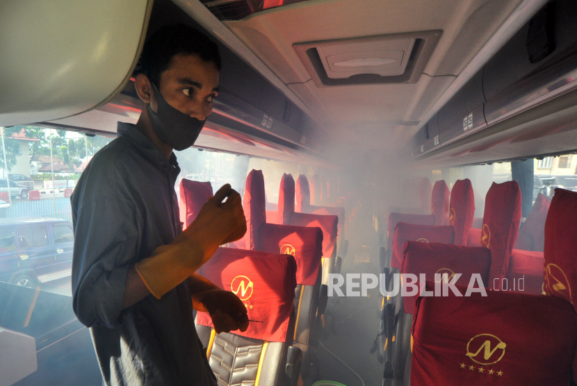 Petugas melakukan sterilisasi bagian dalam bus tujuan Jakarta dengan pengasapan (fogging) disinfektan, di pool PT NPM Padang, Sumatra Barat, Sabtu (4/7/2020). Masyarakat memanfaatkan masa libur panjang untuk bepergian.