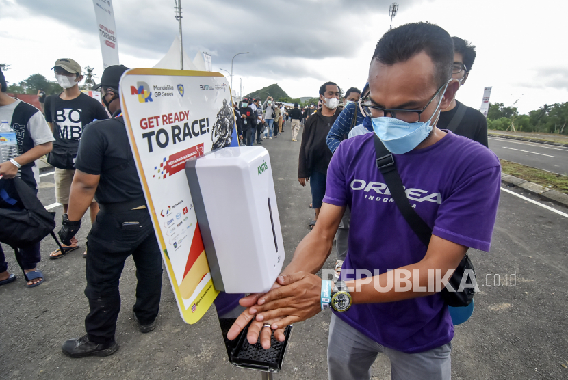 Seorang penonton membersihkan tangan menggunakan cairan pembunuh kuman sebelum memasuki tribun untuk menonton balapan WSBK 2021 di gerbang barat Pertamina Mandalika International Street Circuit di KEK Mandalika, Desa Kuta, Kecamatan Pujut, Praya, Lombok Tengah, NTB, Ahad (21/11). 