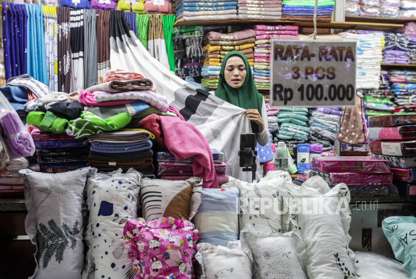 Pedagang berjualan melalui siaran langsung TikTok Shop di Pasar Tanah Abang, Jakarta, Selasa (12/12/2023). TikTok resmi mengumumkan untuk membuka kembali fitur belanja di dalam aplikasi mulai Selasa 12 Desember yang bermitra bersama PT GoTo dengan menggelontorkan investasi senilai Rp1,5 miliar dolar AS atau sekitar Rp23,4 triliun. Menurut pedagang pada hari pertama pengaktifan kembali fitur TikTok Shop dalam kurun waktu setengah hari baru terdapat 1.000 penonton saat melakukan siaran langsung.