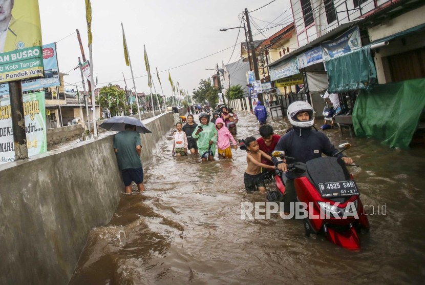Warga mendorong sepeda motornya saat banjir di Banten. Pemda di Banten diminta bersiap antisipasi bencana banjir memasuki musim hujan.