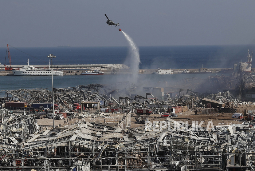  Sebuah helikopter militer menumpahkan air di lokasi ledakan besar Selasa yang menghantam pelabuhan Beirut, Lebanon, Rabu, 5 Agustus 2020. WHO minta bantuan sebesar Rp 1,1 T untuk membantu warga yang terimbas ledakan Lebanon.