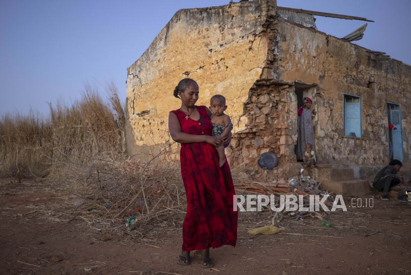  Seorang wanita yang melarikan diri dari konflik di wilayah Tigray Ethiopia menggendong bayinya di depan tempat penampungan sementara di kamp pengungsi Umm Rakouba di Qadarif, Sudan timur, Senin, 7 Desember 2020.