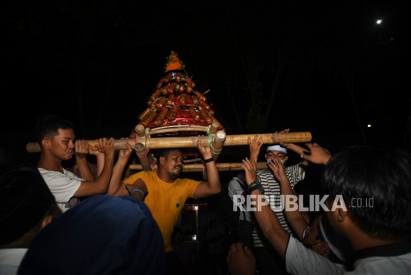 Pemuda mengarak tumpukan mandura keliling kampung pada gelaran Festival Mandura dan Kampung Baru Fair di Palu, Sulawesi Tengah, beberapa waktu lalu. 