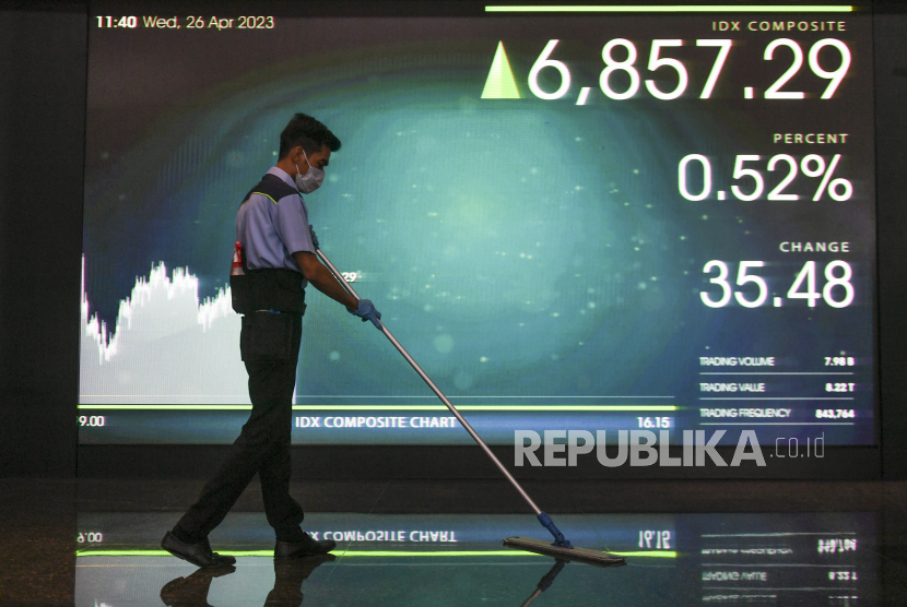 Pekerja membersihkan lantai di depan layar yang menampilkan pergerakan Indeks Harga Saham Gabungan (IHSG) di Bursa Efek Indonesia, Jakarta, Rabu (26/4/2023). Usai cuti bersama Lebaran 2023, Indeks Harga Saham Gabungan (IHSG) pada Rabu (26/4) dibuka menguat 60 poin (0,88 persen) ke 6.877. 