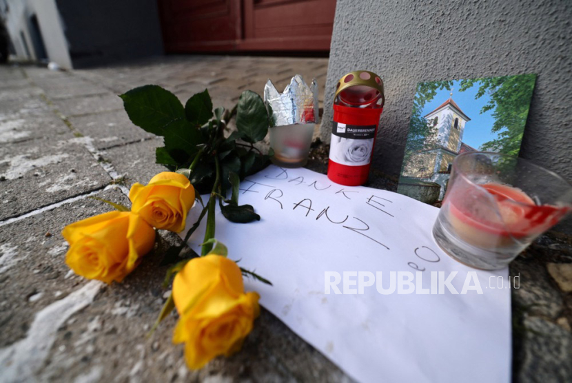 Flowers, candles and a letter reading 