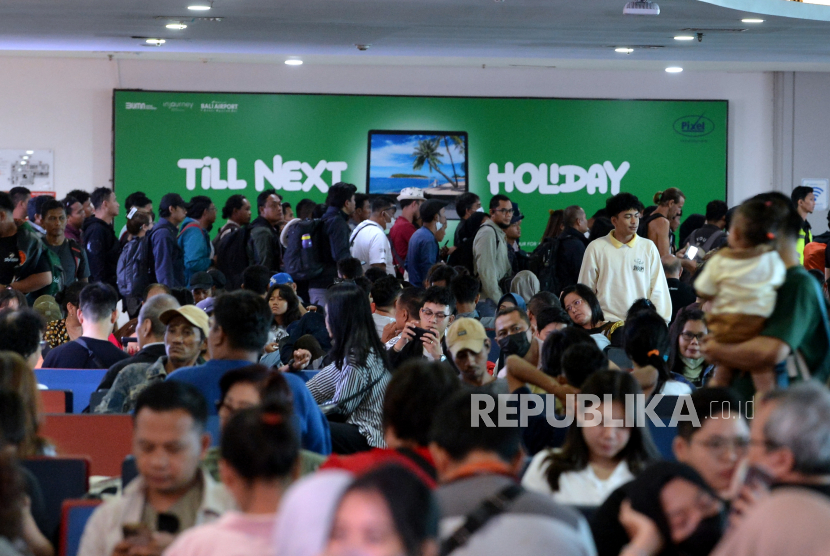 Calon penumpang menunggu jadwal keberangkatan di Terminal Domestik Bandara Internasional I Gusti Ngurah Rai, Badung, Bali, Ahad (7/4/2024). Pemerintah memangkas jumlah bandara internasional jadi 17.