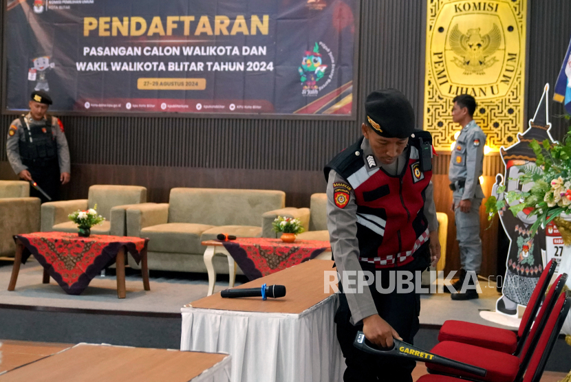 Polisi melakukan sterilisasi di lokasi pendaftaran calon kepala daerah yang akan mengikuti Pemilihan Umum Kepala Daerah (Pilkada) 2024 di kantor KPU Kota Blitar, Jawa Timur, Selasa (27/8/2024).  