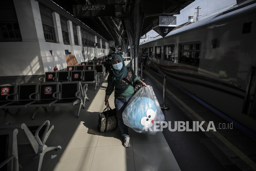 Calon penumpang membawa barang bawaannya di Stasiun Pasar Senen, Jakarta.
