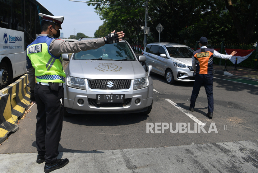 Polisi melarang pengendara mobil berplat nomor ganjil memasuki Jalan Sudirman di kawasan Bundaran Senayan, Jakarta, Kamis (12/8/2021), pada hari pertama penerapan ganjil-genap.