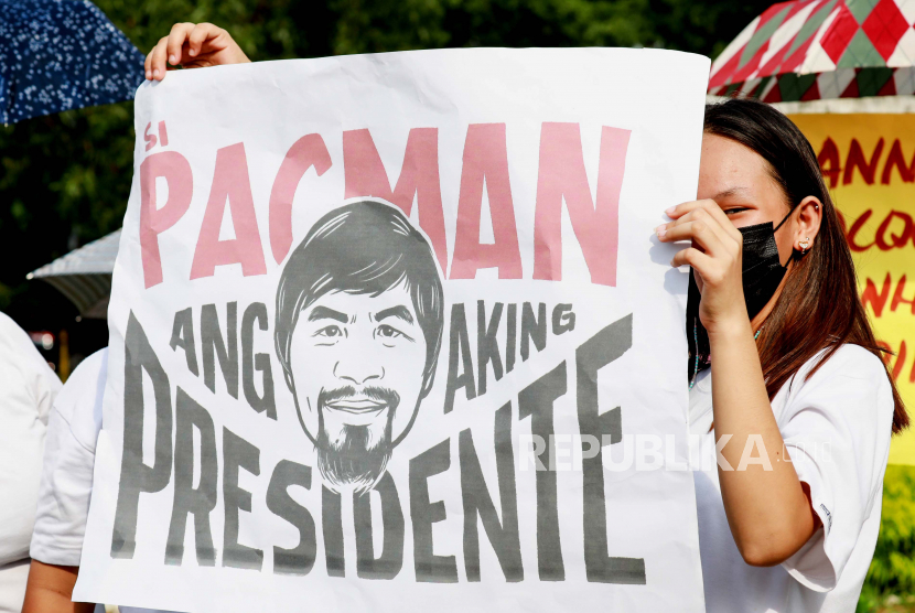  Pendukung Senator Filipina dan ikon tinju Manny Pacquiao membawa spanduk saat mengajukan pencalonan sebagai Presiden Filipina di Manila, Filipina, 01 Oktober 2021. Pengajuan Sertifikat Pencalonan untuk Pemilu Nasional 2022 di Filipina akan berlangsung dari 01 Oktober hingga 08 Oktober 2021.